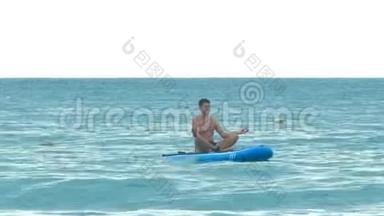 男子坐在瑜伽姿势的桨板上<strong>漂洋过海</strong>